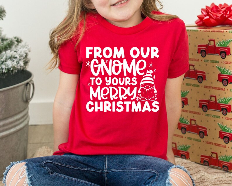 May include: Red t-shirt with white text that says "From our *Gnome* to yours *Merry* Christmas" and a white cartoon gnome wearing a red hat.