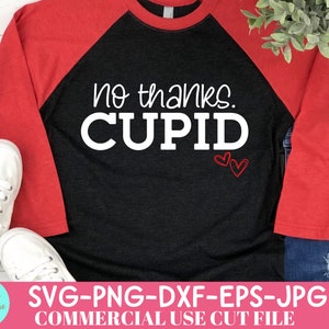 May include: A black and red raglan shirt with the text "no thanks. CUPID" in white. Two red heart outlines are below the text. The shirt is paired with blue jeans and white sneakers.