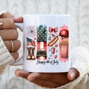 K&ouml;nnte beinhalten: Eine wei&szlig;e Keramiktasse mit einem farbenfrohen Design, das eine amerikanische Flagge, Feuerwerk, einen Jeep, einen Hotdog, Popcorn und den Text "Happy 4th of July" zeigt.