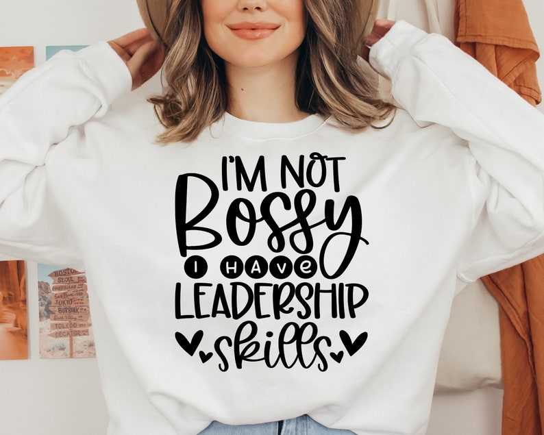 May include: White sweatshirt with black text that reads "I'm not bossy I have leadership skills" with hearts on either side of the word "skills".