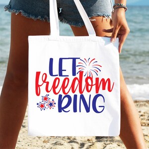 May include: White tote bag with the text "Let Freedom Ring" in red, blue, and white. The text is surrounded by red, white, and blue stars and fireworks.