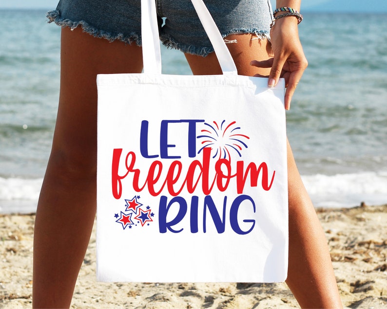 May include: White tote bag with the text "Let Freedom Ring" in red, blue, and white. The text is surrounded by red, white, and blue stars and fireworks.