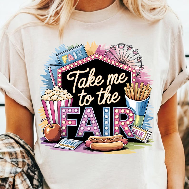 May include: White t-shirt with a colorful graphic design featuring a carnival scene. The design includes a Ferris wheel, popcorn, hot dogs, french fries, and a sign that says "Take me to the fair".