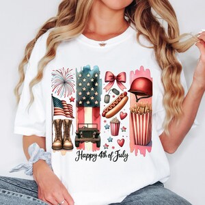 K&ouml;nnte beinhalten: Wei&szlig;es T-Shirt mit einem Grafikdesign, das eine amerikanische Flagge, Feuerwerk, einen Hotdog, Popcorn, einen Jeep und den Text "Happy 4th of July" zeigt.