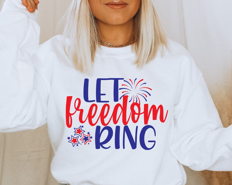 May include: White sweatshirt with the text "Let freedom ring" in red and blue lettering. The text is surrounded by red and blue stars and a firework graphic.