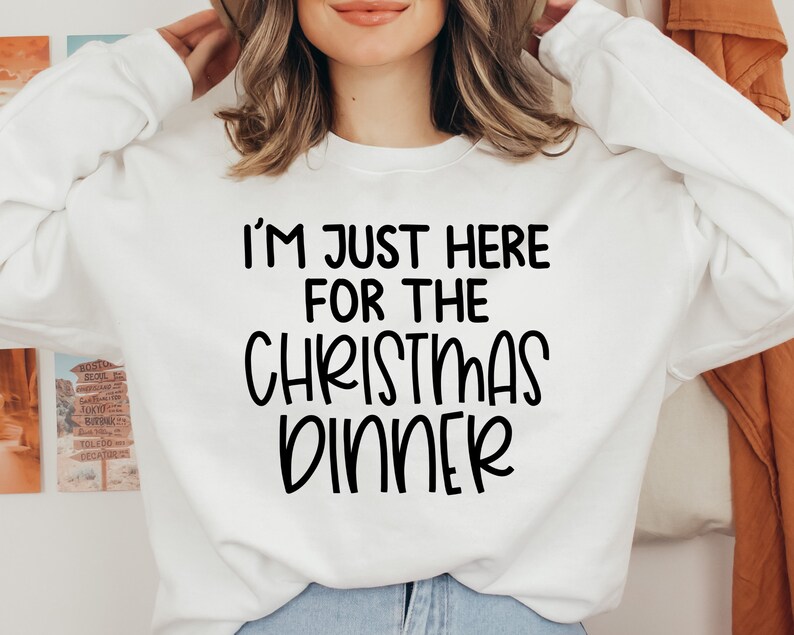 Peut inclure: Sweat-shirt blanc avec un texte noir qui dit "Je suis juste l&agrave; pour le d&icirc;ner de No&euml;l."