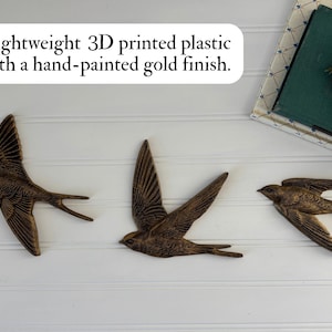 May include: Three lightweight, 3D-printed plastic swallows with a hand-painted gold finish are displayed against a white background. The swallows are in mid-flight, with their wings spread. The text in the image says: Lightweight 3D printed plastic with a hand-painted gold finish.