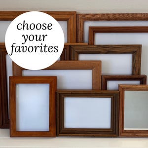 May include: A selection of wooden picture frames in different sizes and shades of brown. The frames feature a classic design and are arranged in a layered composition. The text "choose your favorites" is in a white circle.