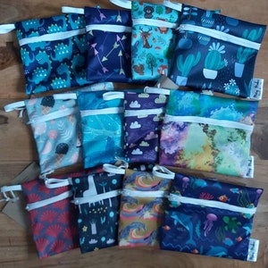 Puede incluir: Doce bolsas con cremallera de colores con varios patrones, incluyendo dinosaurios, flechas, cactus, nubes, helados y escenas del océano. Las bolsas están hechas de tela impermeable y tienen una cremallera blanca.