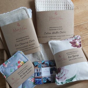 May include: A box filled with eco-friendly cleaning and bath products. The products are made by Mary Makes Zero Waste and include a cotton waffle cloth, an eco cleaning cloth, an eco sponge scourer, and an eco sponge. The products are all handmade in Wirral.