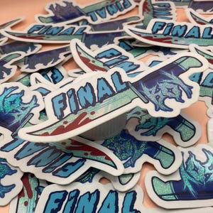 Peut inclure: Plusieurs autocollants avec un motif de couteau et le mot "FINAL" en bleu. Le couteau a une lame verte et un manche bleu et argenté, avec des accents rouges. Les autocollants ont une finition scintillante.