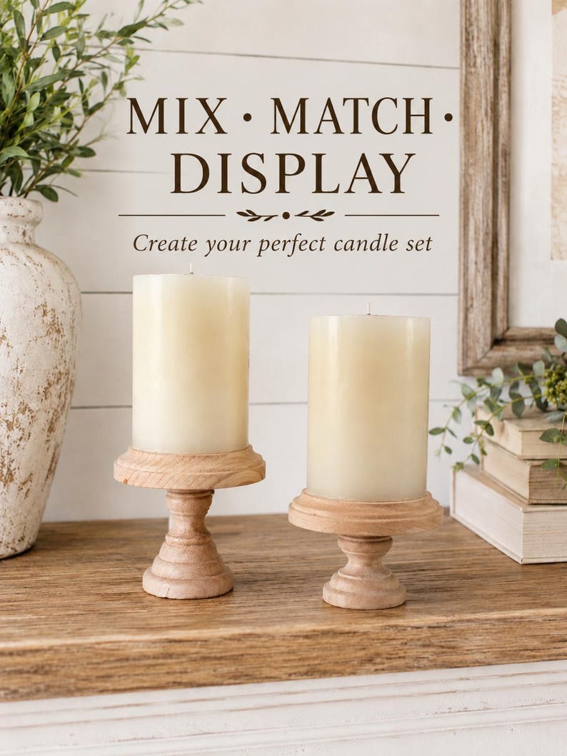 May include: Two ivory pillar candles on light wood pedestals. The candles are cylindrical and unscented. The pedestals have a turned design. The text "MIX &bull; MATCH &bull; DISPLAY" and "Create your perfect candle set" are visible.