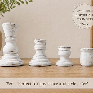 Peut inclure: Quatre bougeoirs en bois blanc vieilli de diff&eacute;rentes hauteurs. Les bougeoirs ont un style rustique et champ&ecirc;tre. Le texte "AVAILABLE INDIVIDUALLY OR IN SETS" est dans un graphique circulaire. Le texte "Perfect for any space and style" est en dessous.