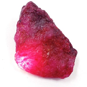 Puede incluir: Una gran gema de rubí rojo sin pulir. El rubí tiene un color rojo intenso y rico y es translúcido.