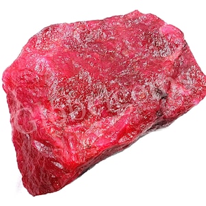 Peut inclure: Une grosse pierre précieuse de rubis rouge brute. Le rubis est d'une couleur rouge foncé et riche et a une surface naturelle non polie.