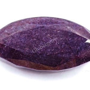 Peut inclure: Une pierre précieuse violette de forme marquise. La pierre précieuse est d'une couleur violette profonde et a une surface lisse et polie.