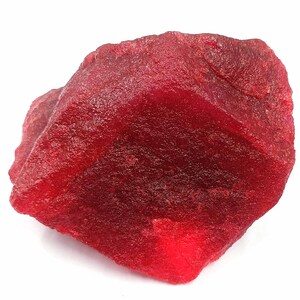 Puede incluir: Una gran gema de rubí rojo sin pulir. El rubí tiene un color rojo intenso y rico y una superficie ligeramente texturizada.