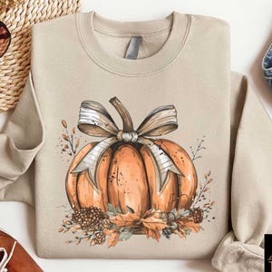 a sweater with a pumpkin on it next to a pair of shoes