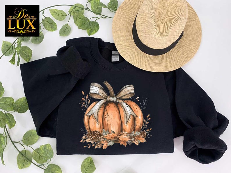 a black sweatshirt with a pumpkin and bow on it