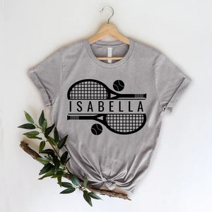 a t - shirt with a tennis racket and ball on it