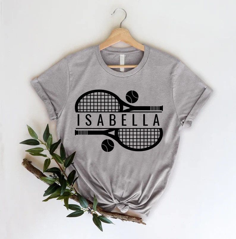 a t - shirt with a tennis racket and ball on it