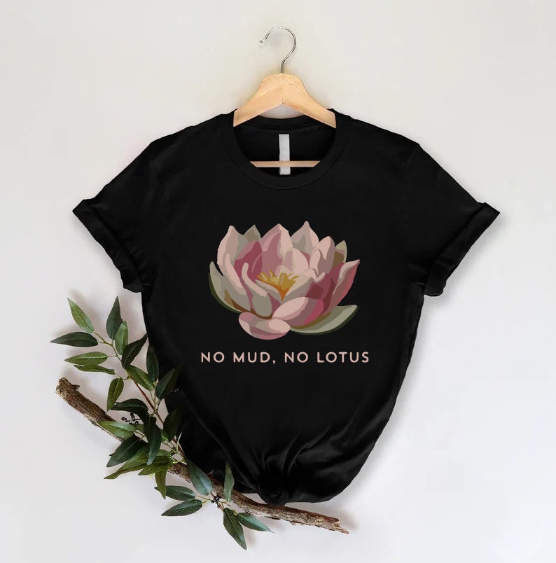 a black t - shirt with a pink flower on it that says no mud,