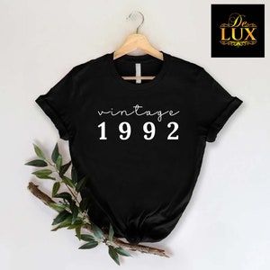 a black t - shirt with the words vintage 1932 printed on it