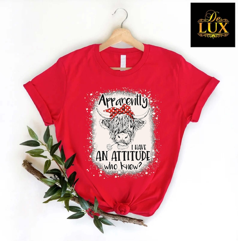 a red shirt with an image of a cow wearing a bow