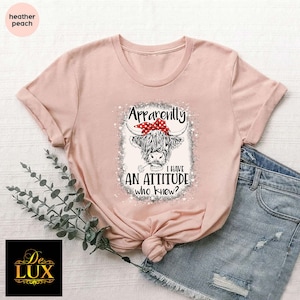 a pink shirt with an image of a cow wearing a bow
