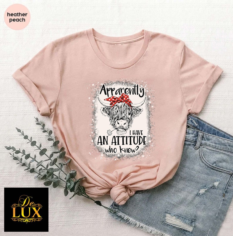 a pink shirt with an image of a cow wearing a bow