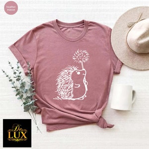a t - shirt with a hedge on it next to a hat