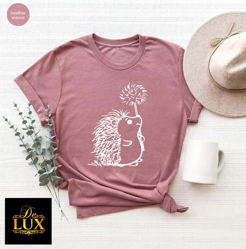 a t - shirt with a hedge on it next to a hat