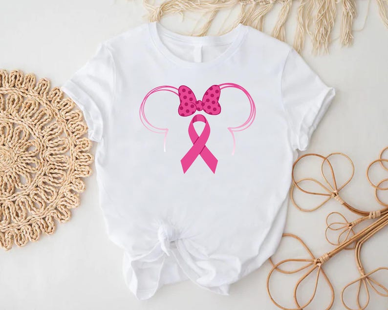 a minnie mouse shirt with a pink ribbon on it