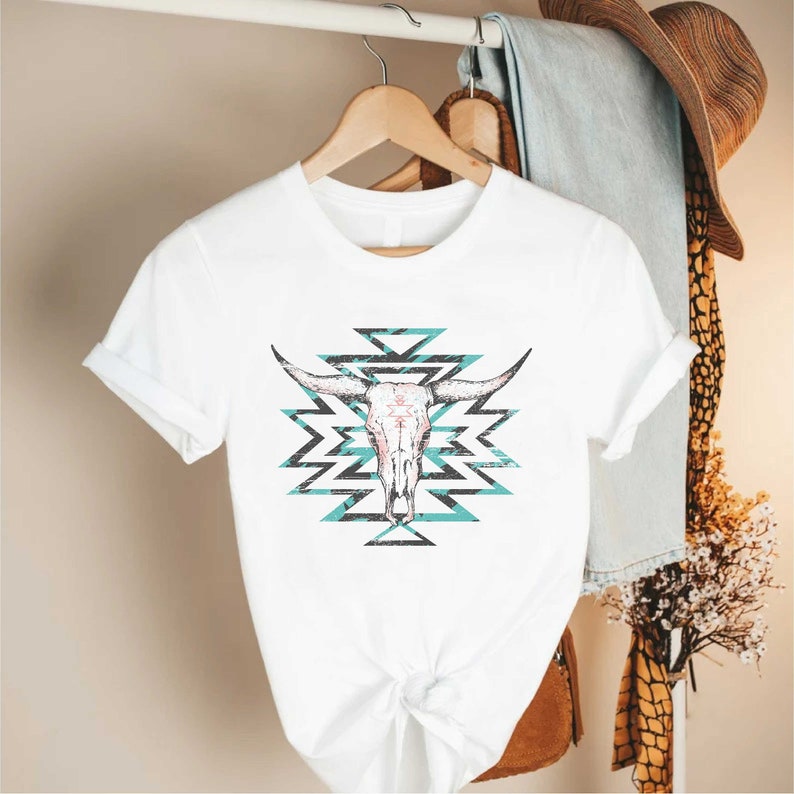 a white t - shirt with a cow skull on it