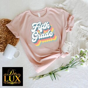 a pink shirt with the words fifth grade on it