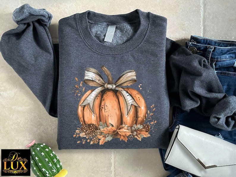 a gray shirt with a pumpkin and a bow on it