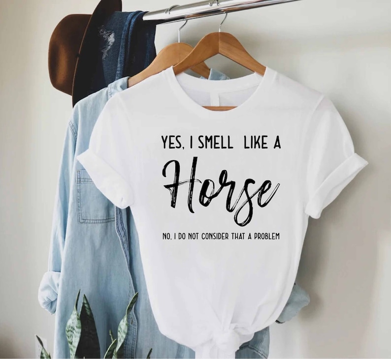 a white shirt that says, yes i smell like a horse in it's