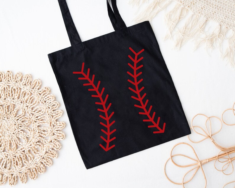 May include: Black tote bag with red baseball stitching design. The bag has two long handles and is made of a durable fabric. The baseball-themed design is a bold and eye-catching detail.