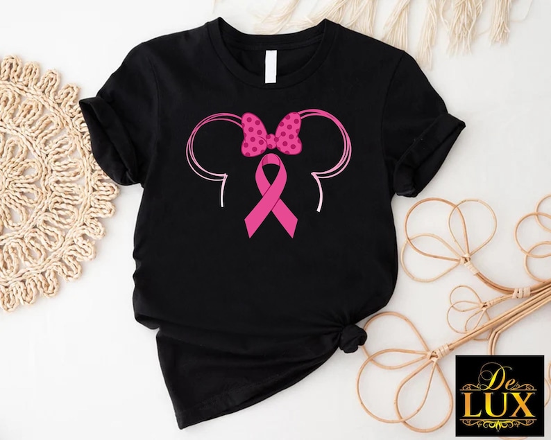 a black shirt with a pink ribbon and minnie mouse ears