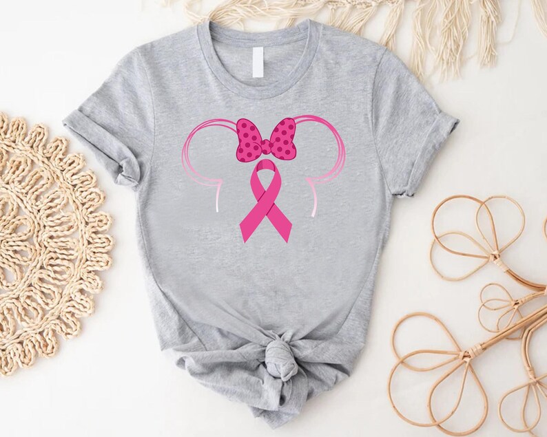 a gray shirt with a pink ribbon and minnie mouse ears