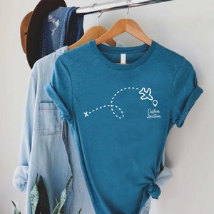 a t - shirt hanging on a clothes rack next to a hat