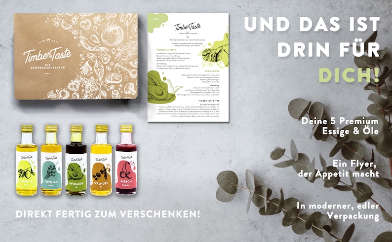 May include: A gift box set of five small glass bottles containing premium oils and vinegars. The bottles are labeled with the brand name "Timber Taste" and have illustrations of various ingredients. The box is brown with a white illustration of various ingredients. The text "UND DAS IST DRIN F&Uuml;R DICH!" is written in white on a gray background. The text "Deine 5 Premium Essige & &Ouml;le" is written in black on a white background. The text "Ein Flyer, der Appetit macht" is written in black on a white background. The text "In moderner, edler Verpackung" is written in black on a white background.
