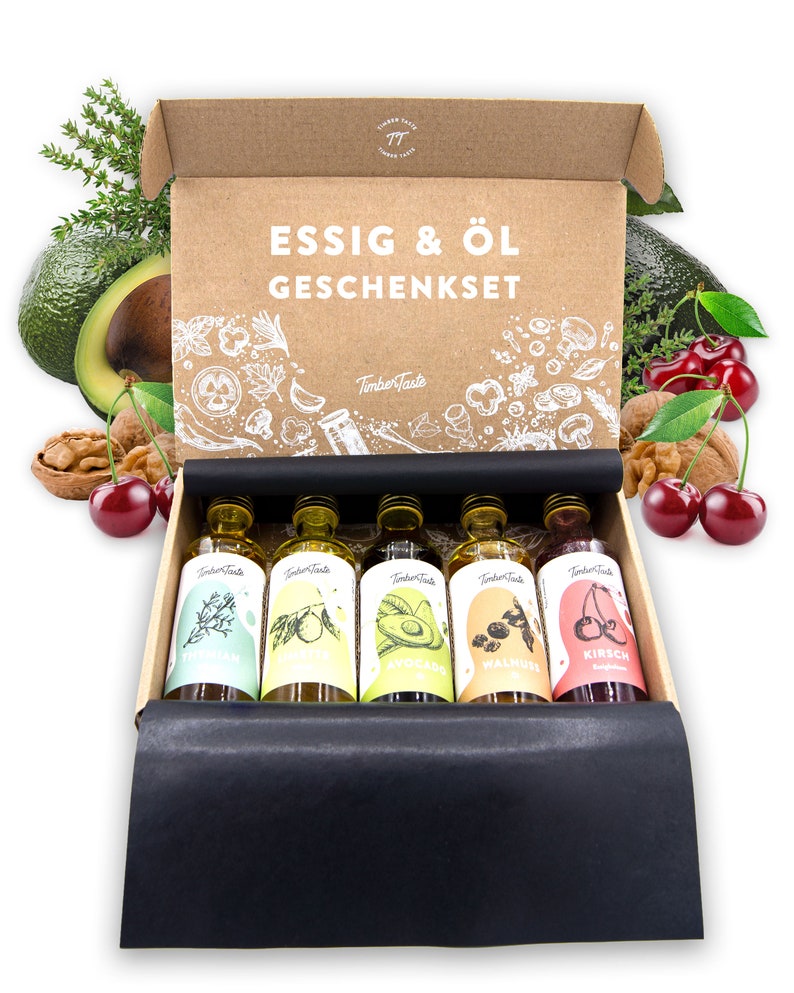 May include: A brown cardboard box with a black lid, containing six small glass bottles of oil and vinegar. The bottles are labeled with different flavors, including avocado, walnut, and cherry. The box is decorated with the text "ESSIG & &Ouml;L GESCHENKSET" and the logo "TimberTaste".
