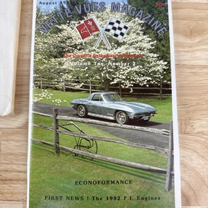 May include: A vintage magazine cover for Vette Vues Magazine, August 1983. The cover features a silver-blue Corvette on a road, with a green and white landscape. The magazine title and issue details are displayed at the top.