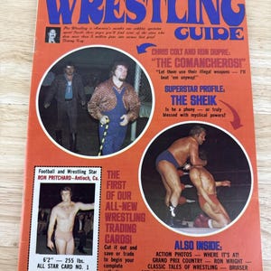 May include: Vintage wrestling magazine cover with the title "Wrestling Guide" in blue and orange. Features images of wrestlers, including Ron Pritchard, and text about wrestling stars and trading cards. The magazine is from November 1973.