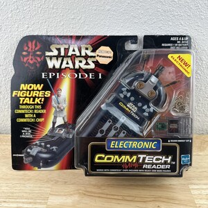 May include: Star Wars Episode I Electronic CommTech Reader toy in original packaging. The black and silver reader is in a clear plastic case with the Star Wars logo and text. Ages 4 & up.