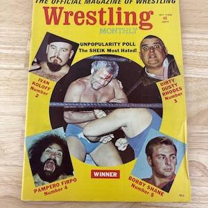 May include: Vintage "Wrestling Monthly" magazine with a yellow cover. The cover features portraits of wrestlers, including Ivan Koloff, Dirty Dusty Rhodes, and Bobby Shane. The magazine's title is in large red letters, with the text "UNPOPULARITY POLL The SHEIK Most Hated!"