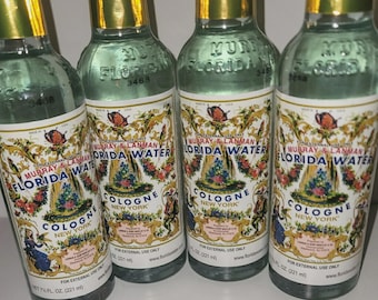 May include: Four clear glass bottles of Murray & Lanman Florida Water Cologne, each featuring a gold foil cap and a decorative label with floral motifs, a butterfly, and the text Florida Water Cologne New York, 7.5 fl oz (221 ml).