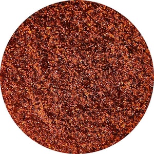 May include: A close-up of a round container filled with fine, sparkly, copper-colored glitter.