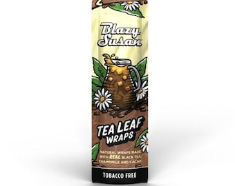 May include: A vertical package of "Blazy Susan" tea leaf wraps. The package is primarily yellow and brown, with the brand name in a stylized font. The design includes images of tea leaves, chamomile flowers, and a brown pitcher. The text reads "Tobacco Free."